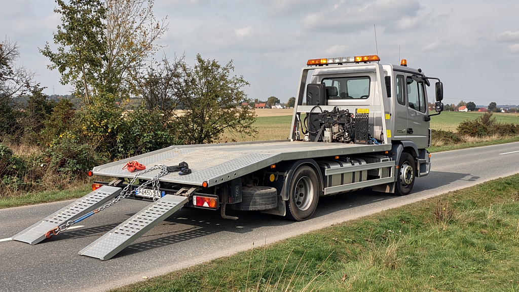 Laweta pomocy drogowej gotowa do załadunku samochodu z wyciekiem oleju